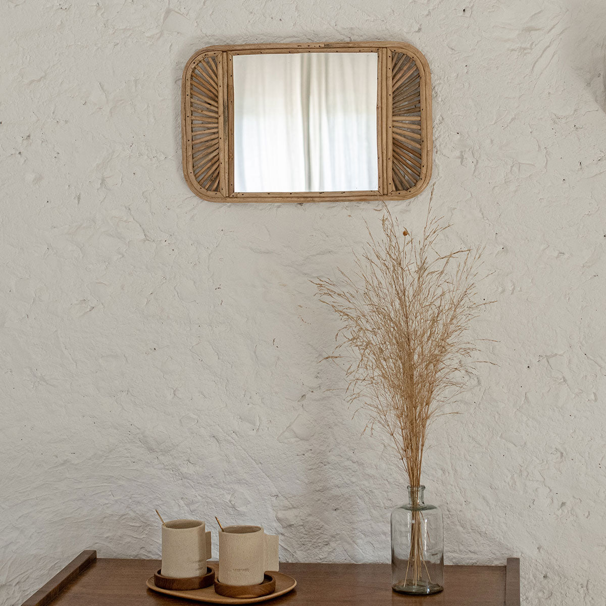 Espejo para colgar en pared, con marco decorado realizado en ratán.
